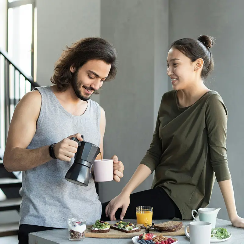 Group of people enjoying a healthy breakfast with fruits, granola, and smoothies