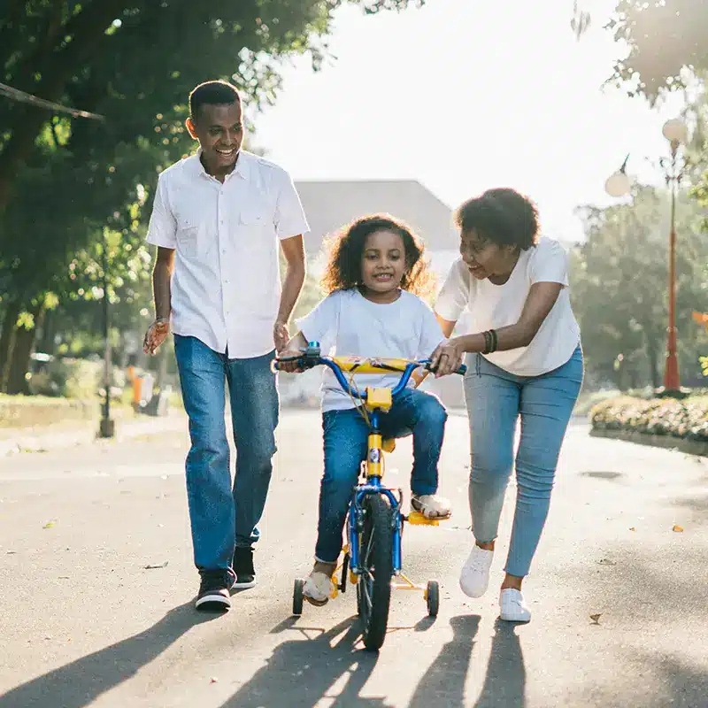A happy and healthy family walking together on a city street.