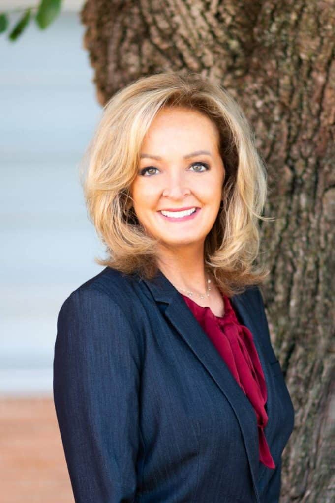 Dana Mercer smiling outdoors in a close-up portrait.